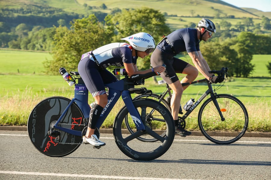 Cyclists on the Lakesman bike course with the Lake District fells behind