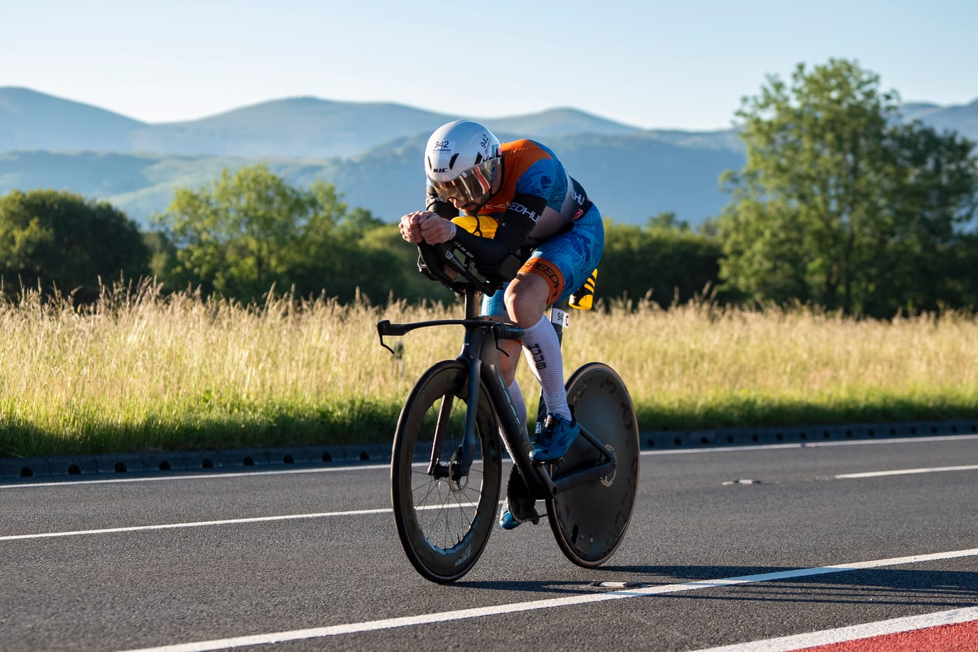Lakesman athlete racing on the time-trial bike with the Lake District fells behind