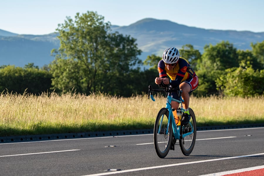 Lakesman athlete racing on the time-trial bike with the Lake District fells behind