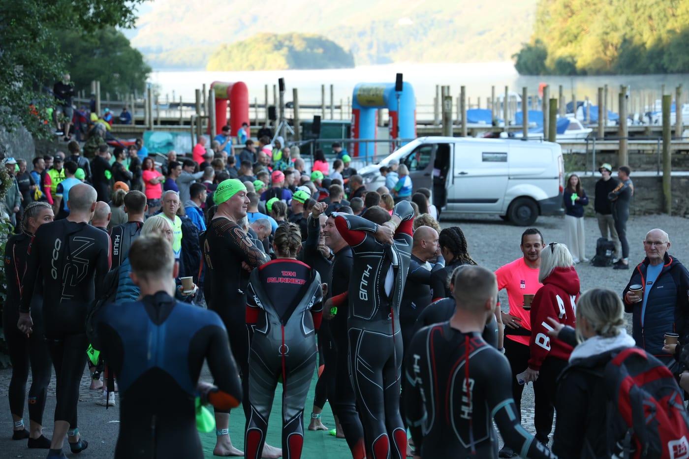 Athletes in wetsuits gathering at the Derwentwater swim start