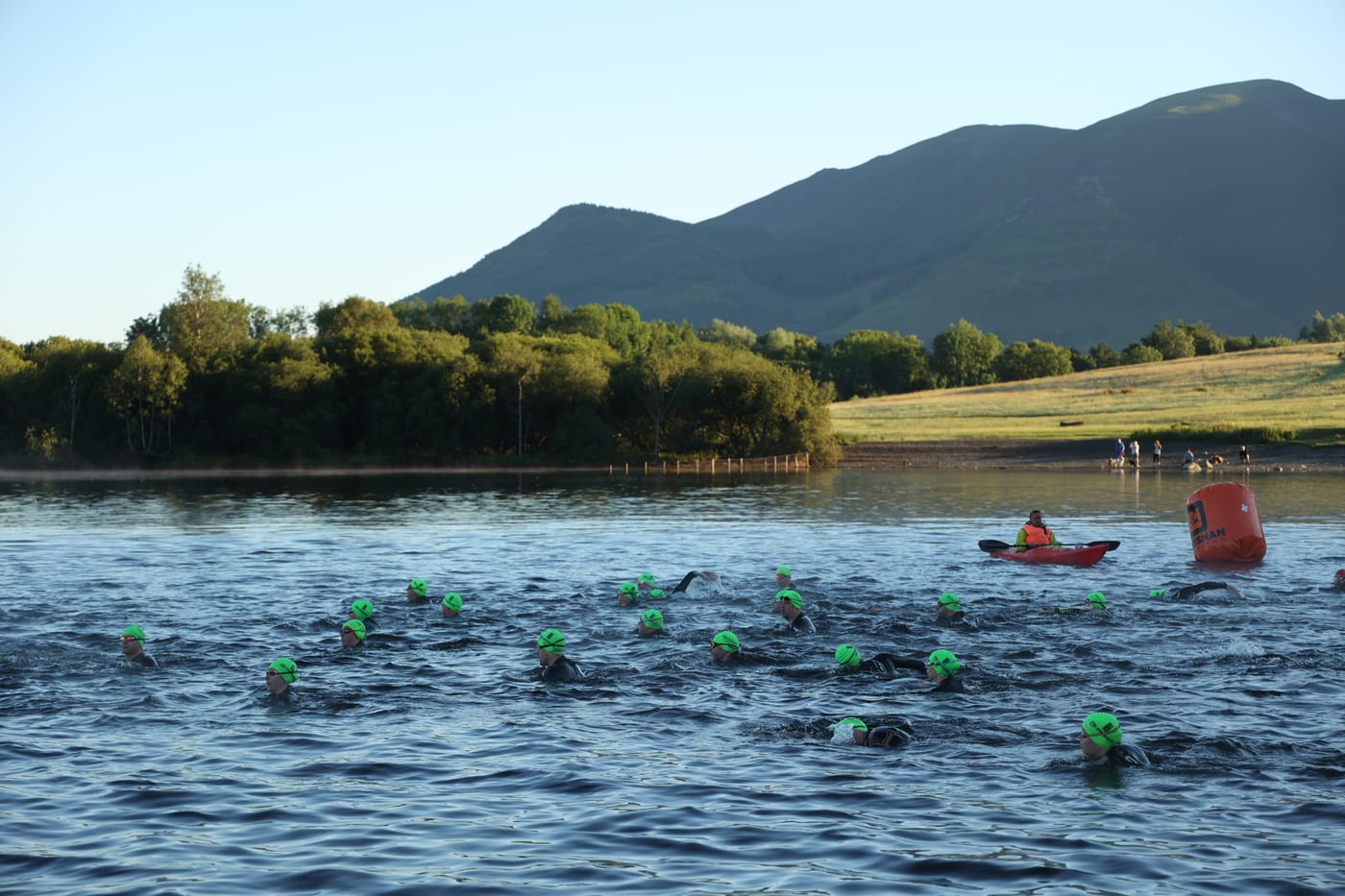 Open-water swimmers on Derwentwater with a safety kayak